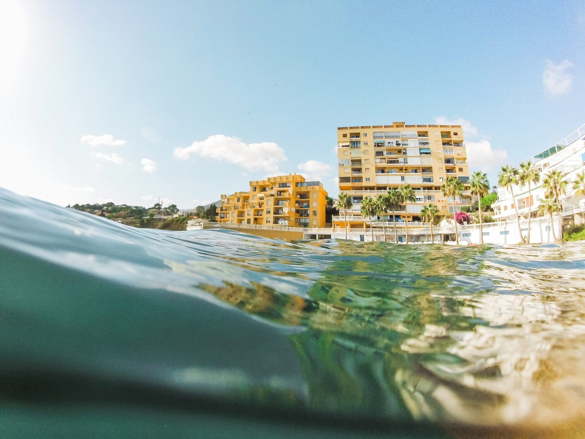 Beachfront apartments with palm trees viewed from the sea in Cyprus.