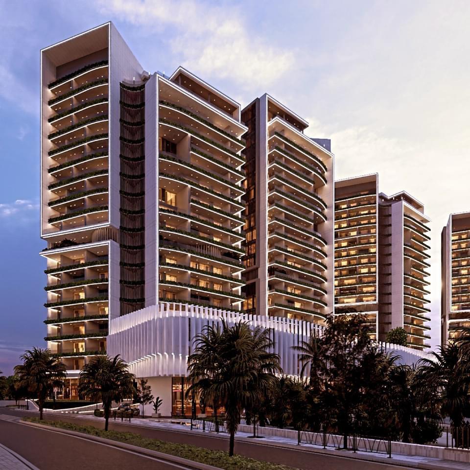 Modern high-rise residential towers with illuminated balconies and lush landscaping in a new development project in Cyprus.